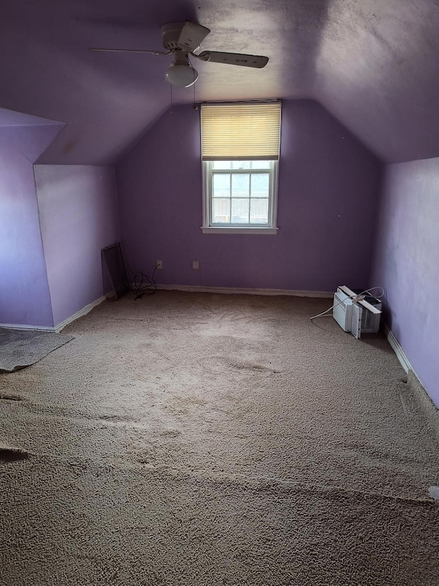 additional living space with vaulted ceiling, carpet floors, a textured ceiling, and ceiling fan