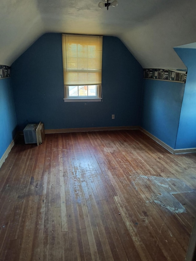 additional living space featuring hardwood / wood-style flooring and vaulted ceiling