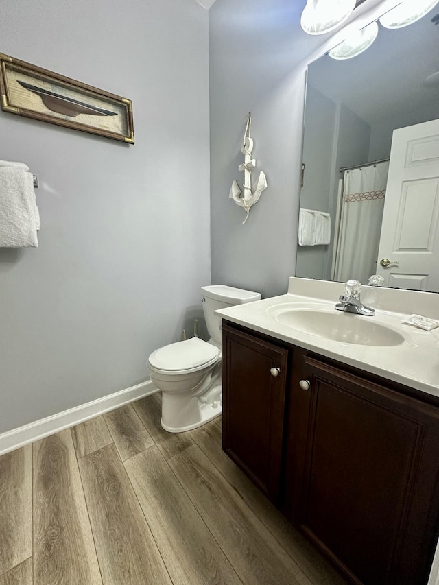 bathroom featuring vanity, toilet, and wood-type flooring