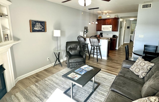 living room featuring light hardwood / wood-style flooring and ceiling fan