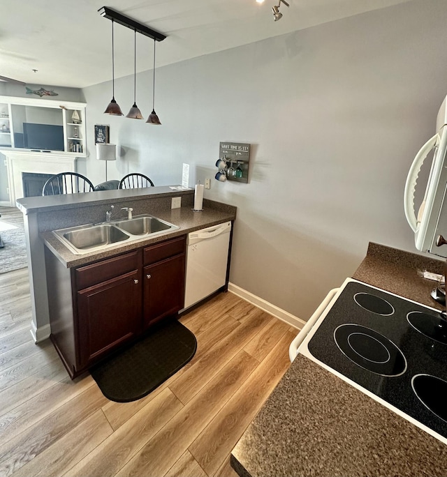 kitchen featuring white dishwasher, sink, decorative light fixtures, light hardwood / wood-style flooring, and dark brown cabinets