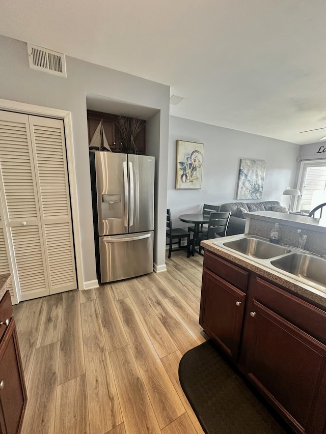 kitchen featuring stainless steel fridge with ice dispenser, sink, ceiling fan, and light wood-type flooring