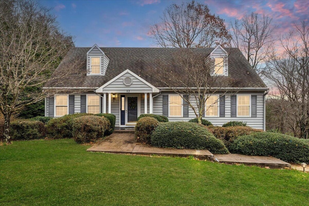 new england style home with a lawn