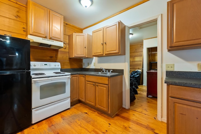 kitchen with dark countertops, under cabinet range hood, freestanding refrigerator, white electric range, and a sink