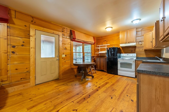 kitchen with wooden walls, white range with electric cooktop, freestanding refrigerator, under cabinet range hood, and dark countertops