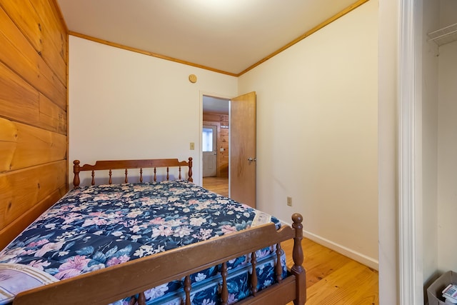 bedroom featuring crown molding, wood finished floors, and baseboards