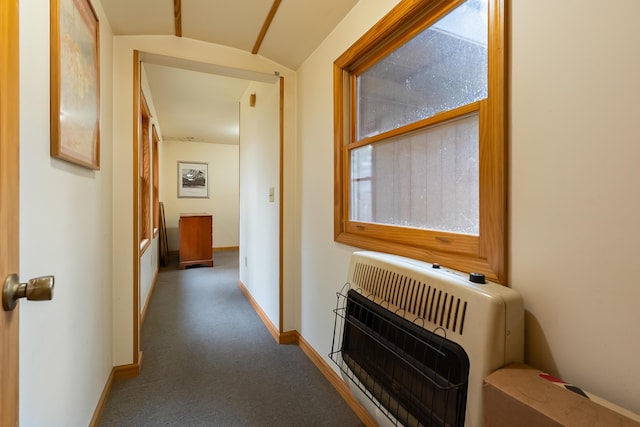 hallway featuring baseboards, heating unit, and carpet flooring