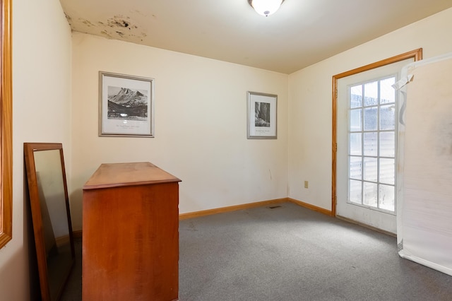 spare room featuring baseboards and carpet floors