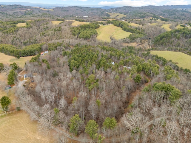 aerial view featuring a wooded view and a mountain view