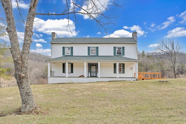 farmhouse featuring a front yard, covered porch, and a chimney