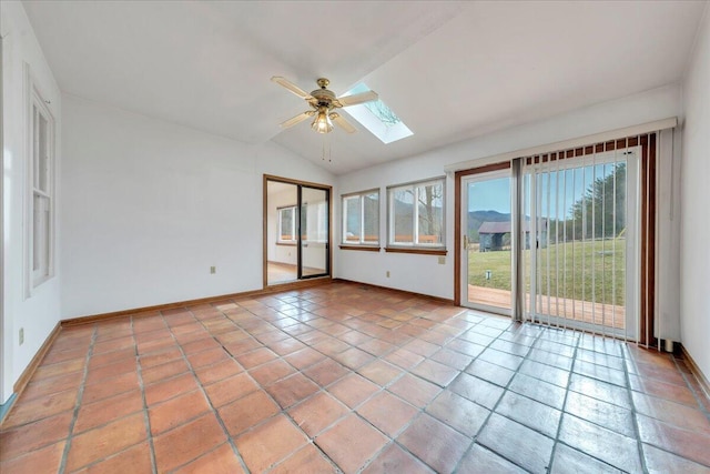 unfurnished sunroom featuring vaulted ceiling with skylight and a ceiling fan