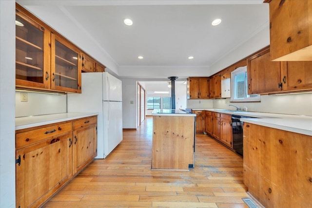 kitchen featuring plenty of natural light, light wood-style flooring, a center island, and freestanding refrigerator