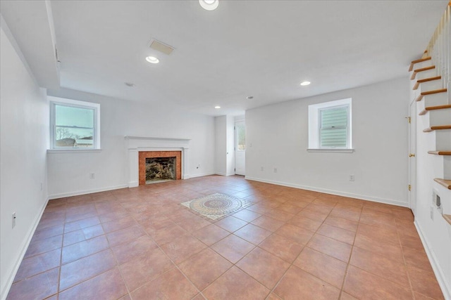 unfurnished living room with recessed lighting, stairway, a fireplace, and light tile patterned floors