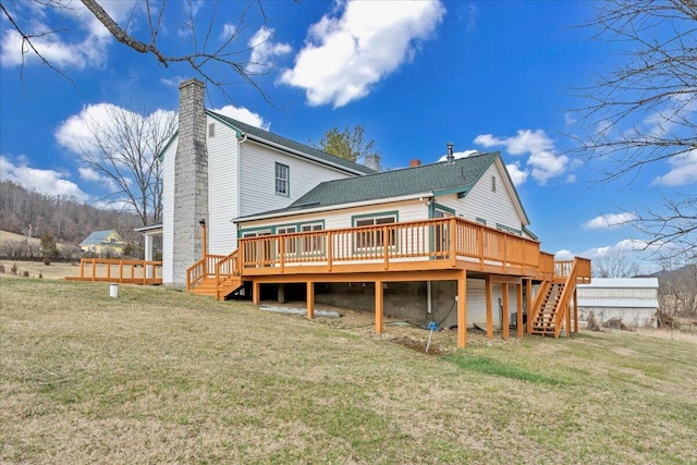 rear view of house with a yard, a wooden deck, a chimney, and stairway