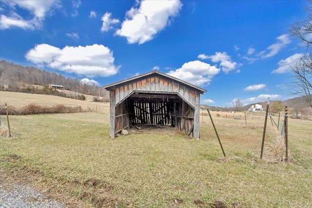 view of pole building featuring a rural view and a lawn