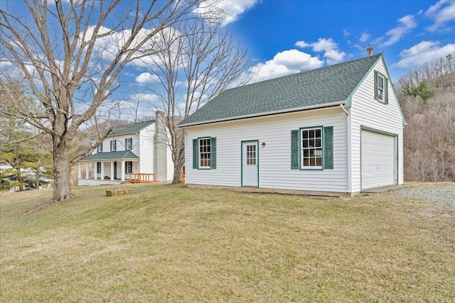 view of front of house featuring a front yard, a garage, and a shingled roof