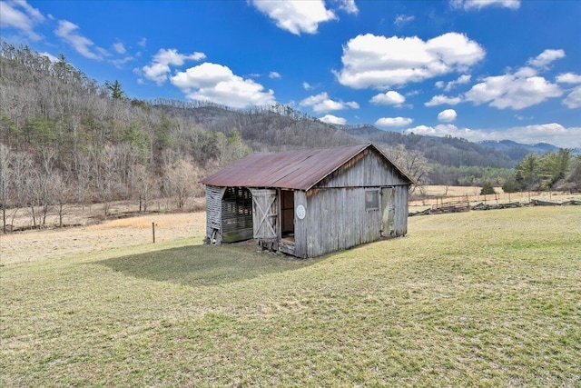 view of pole building featuring a mountain view, a yard, and a forest view