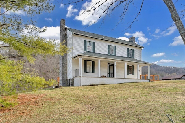 farmhouse inspired home with a front yard, a porch, and a chimney