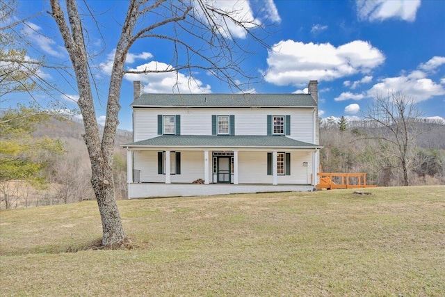 farmhouse inspired home featuring covered porch, a chimney, and a front yard