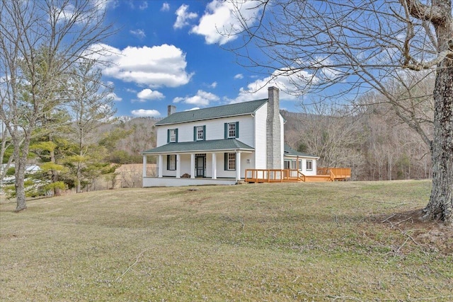 view of front of property featuring a front lawn, covered porch, and a chimney