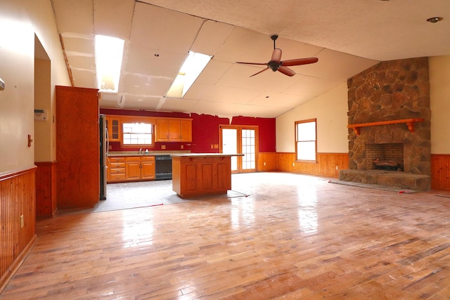 kitchen with a center island, lofted ceiling, dishwasher, and light hardwood / wood-style flooring