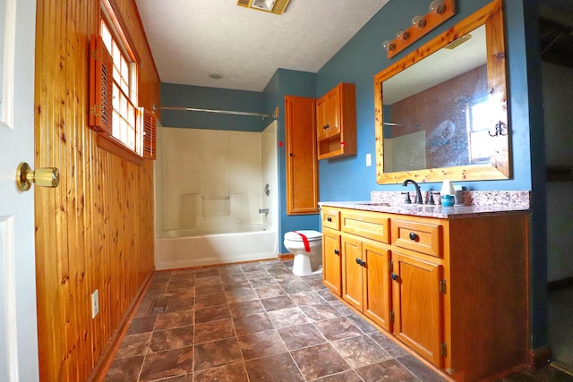 full bathroom featuring vanity, tub / shower combination, wooden walls, and toilet