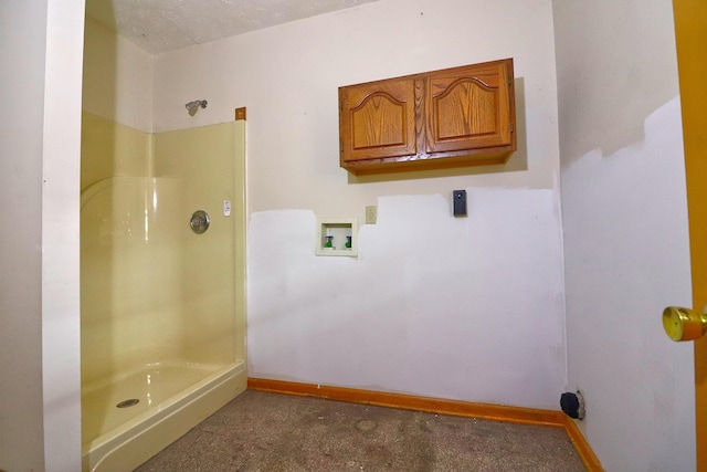 bathroom featuring a shower and a textured ceiling