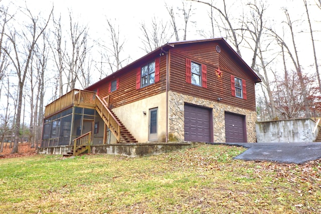 view of property exterior featuring a yard, a garage, and a sunroom