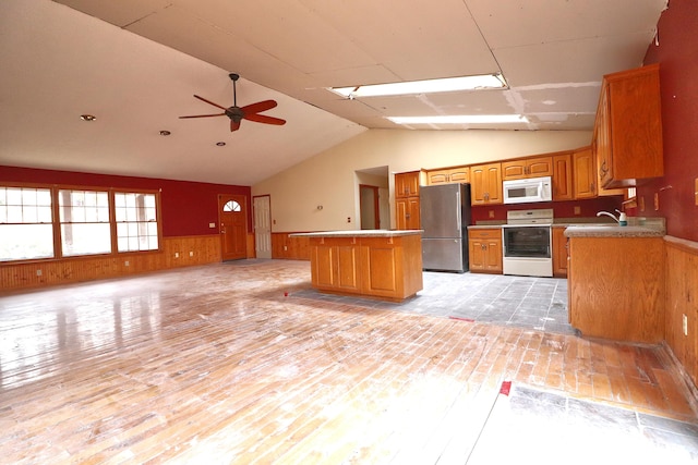 kitchen featuring vaulted ceiling, light wood-type flooring, and white appliances