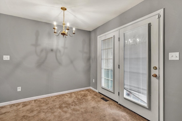 entryway featuring carpet and a chandelier