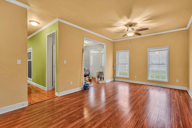 empty room featuring ceiling fan, wood-type flooring, and crown molding