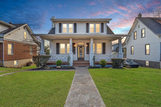 view of front facade featuring a lawn and covered porch