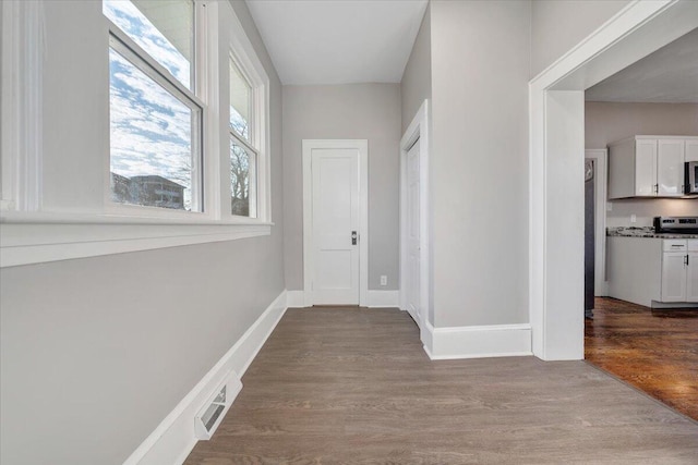 corridor with a healthy amount of sunlight and light hardwood / wood-style floors