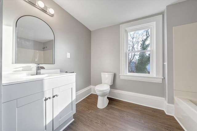 full bathroom featuring toilet, hardwood / wood-style floors, vanity, and washtub / shower combination