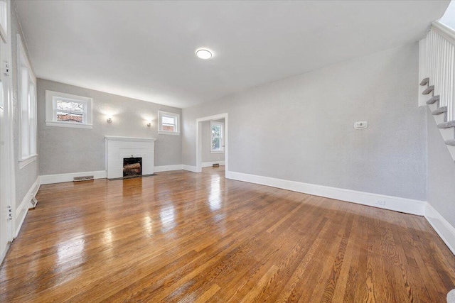 unfurnished living room featuring wood-type flooring and a fireplace