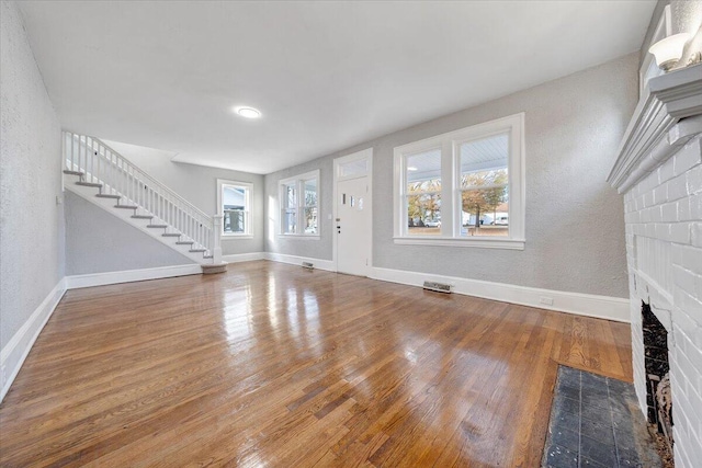 unfurnished living room featuring hardwood / wood-style flooring and a fireplace