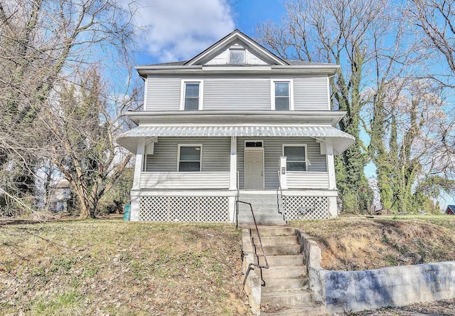 view of property featuring covered porch and a front lawn