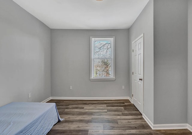 bedroom with dark hardwood / wood-style flooring