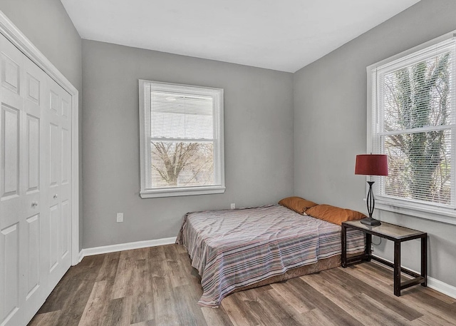 bedroom with light hardwood / wood-style flooring and a closet