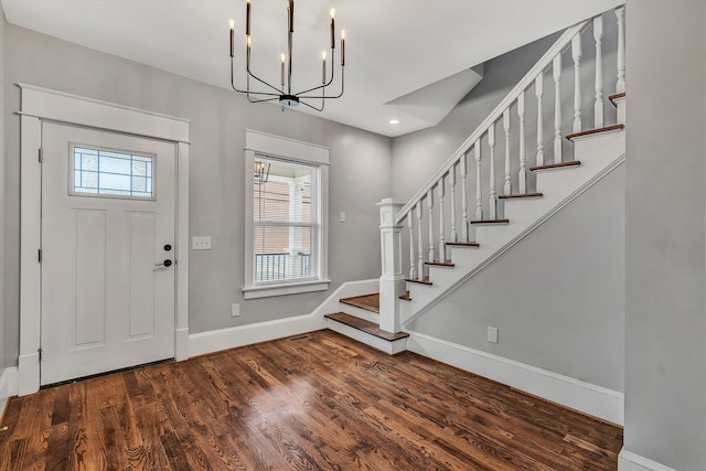 entrance foyer featuring dark hardwood / wood-style flooring and an inviting chandelier