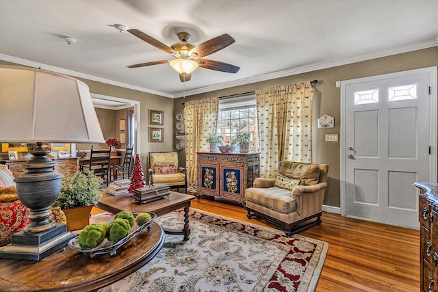 living room featuring ceiling fan, wood-type flooring, and ornamental molding