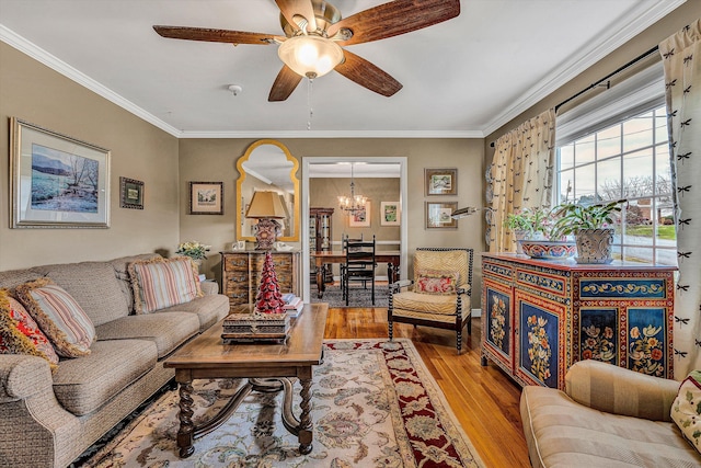 living room featuring light hardwood / wood-style flooring, ceiling fan with notable chandelier, and ornamental molding