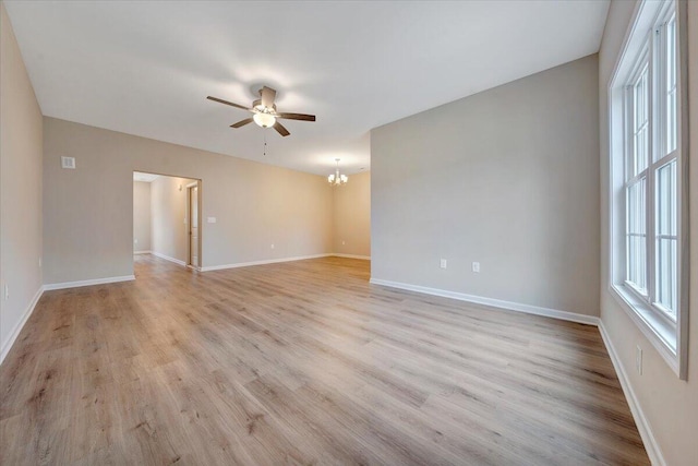 spare room with light hardwood / wood-style floors and ceiling fan with notable chandelier