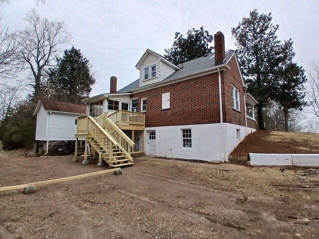 back of house with a wooden deck and a sunroom