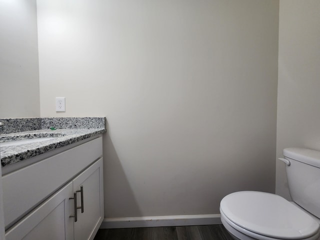 bathroom featuring vanity, hardwood / wood-style flooring, and toilet