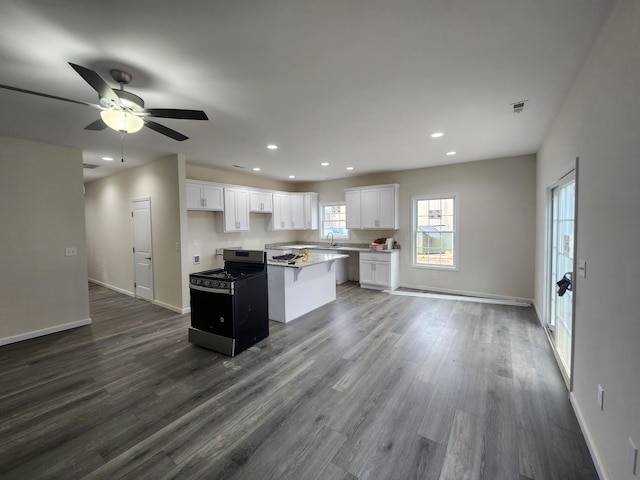 kitchen with a center island, sink, ceiling fan, dark hardwood / wood-style flooring, and white cabinetry