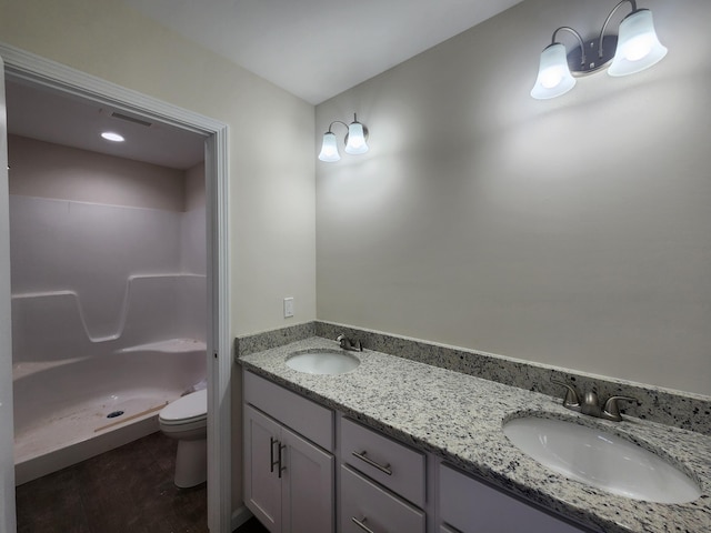 bathroom featuring vanity, toilet, and walk in shower