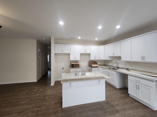 kitchen with a center island, dark hardwood / wood-style flooring, white cabinetry, and sink