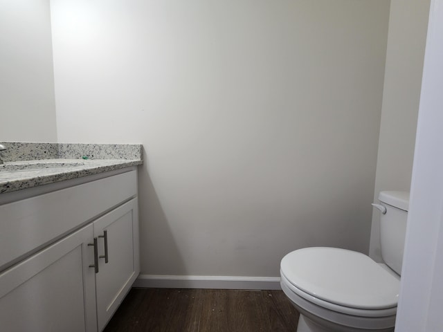 bathroom with vanity, toilet, and wood-type flooring