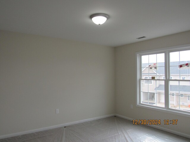 spare room featuring visible vents and baseboards